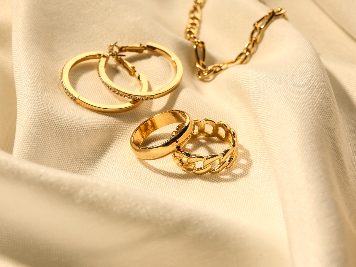 Image of gold jewelry on a satin background.