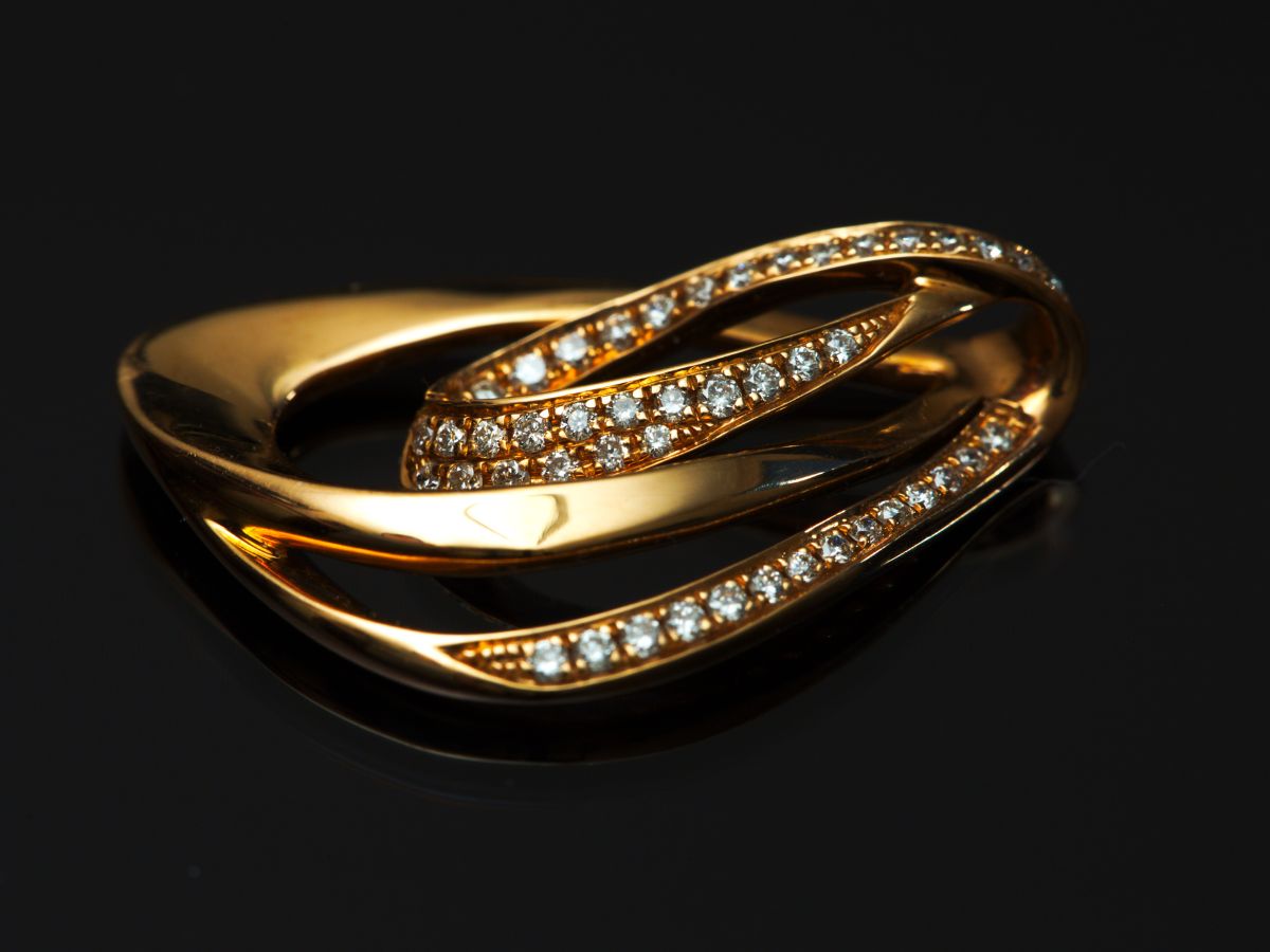 Closeup image of a diamond and gold ring. Get an appraisal for your estate jewelry.