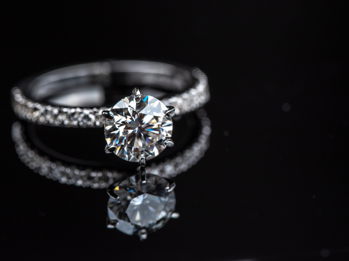 Image of a diamond engagement ring against a black background